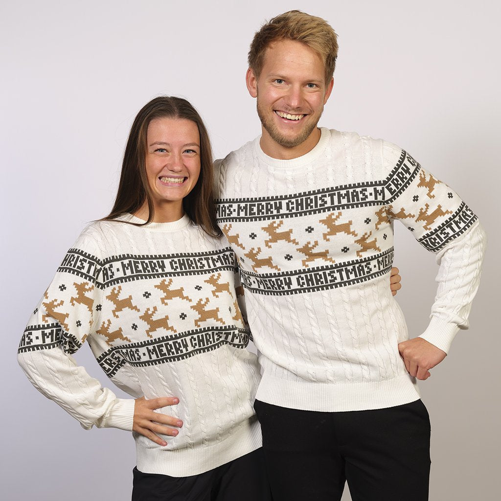 Una coppia che indossa un maglione natalizio bianco con le renne.